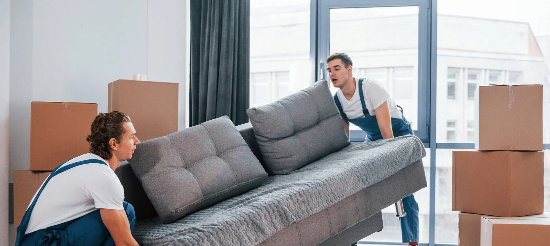 فريق نقل أثاث محترف يحمل الأثاث في شاحنة في دبي الإمارات - شركة الجسر للنقل